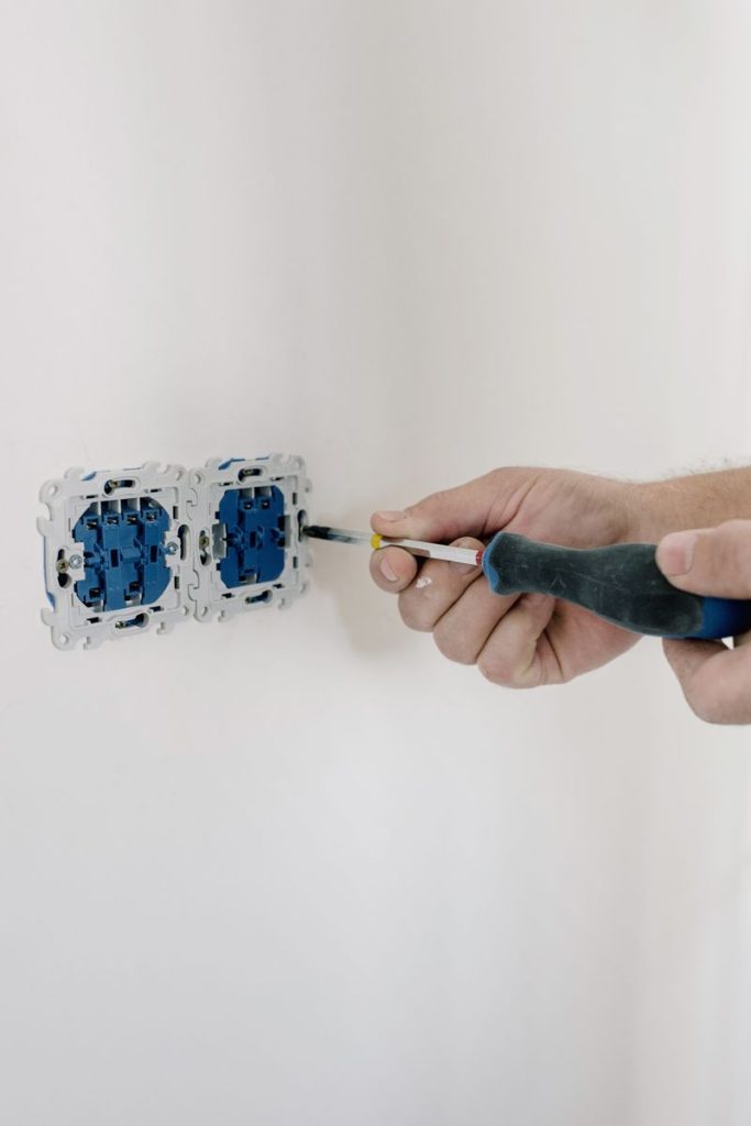 pexels photo 5691589 5691589 Crop faceless man using screwdriver for installation switches in apartment with light wall in daytime